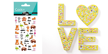 Auf der linken Seite befindet sich ein Aufkleberbogen Cooky mit verschiedenen Comic-Tieren wie Katzen und Flamingos. Auf der rechten Seite besteht das Wort „LOVE“ aus gelben Buchstaben, die mit kleinen bunten Herzen gefüllt sind, und das „O“ hat die Form eines Herzens.