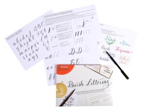 Mehrere Übungsblätter für Brush Lettering sind ausgebreitet, mit Alphabeten, bunten Beispielsätzen und Übungsstrichen. Ein Stift, ein Brush Lettering-Heft und Brause kalligrafie schreibfedern sind ebenfalls auf dem Bild zu sehen.